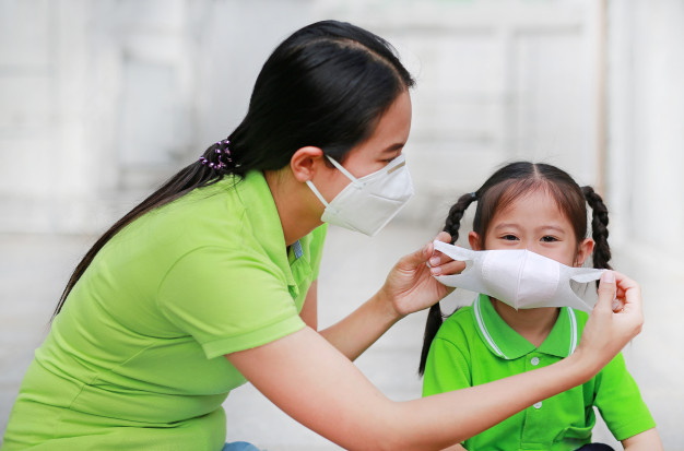 woman wearing protective mask for girl