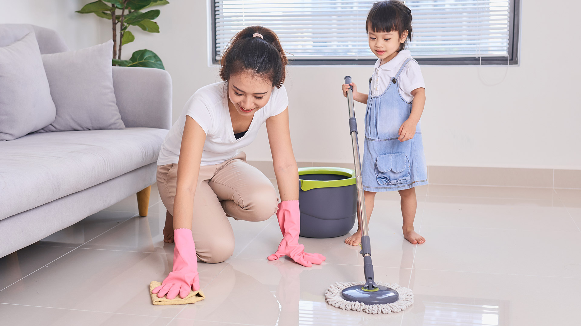 nanny housekeeper looking after kids while moping