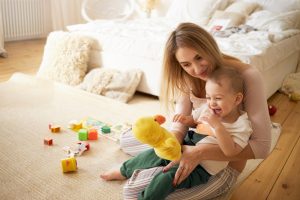 pretty-sister-spending-time-with-her-baby-brother-sitting-floor-bedroom-beautiful-young-babysitter-playing-with-little-boy-indoors-holding-stuffed-toy-duck-infancy-childcare-motherhood
